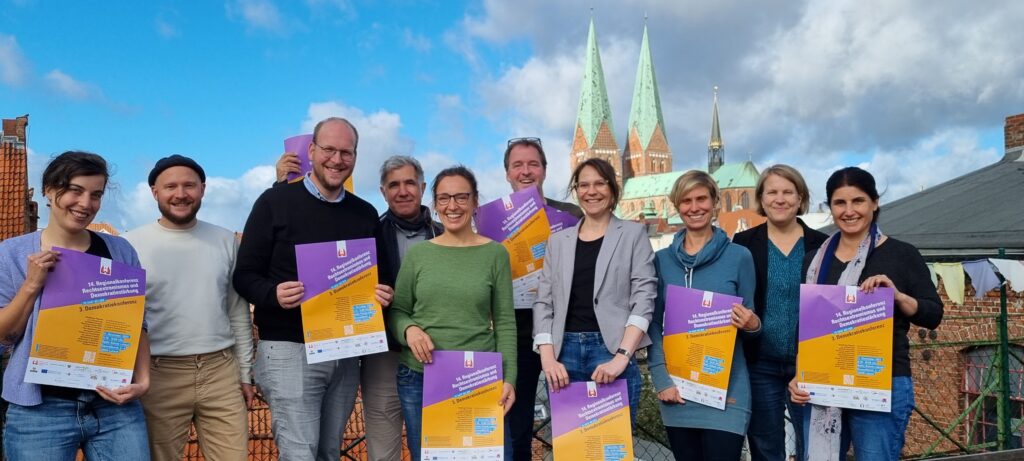 Das Bild zeigt das Organisationsteam der 14. Regionalkonferenz vor der Marienkirche in Lübeck